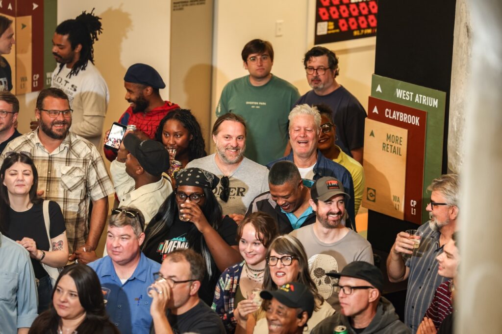 A tightly packed group of smiling guests crowds in close to the camera.