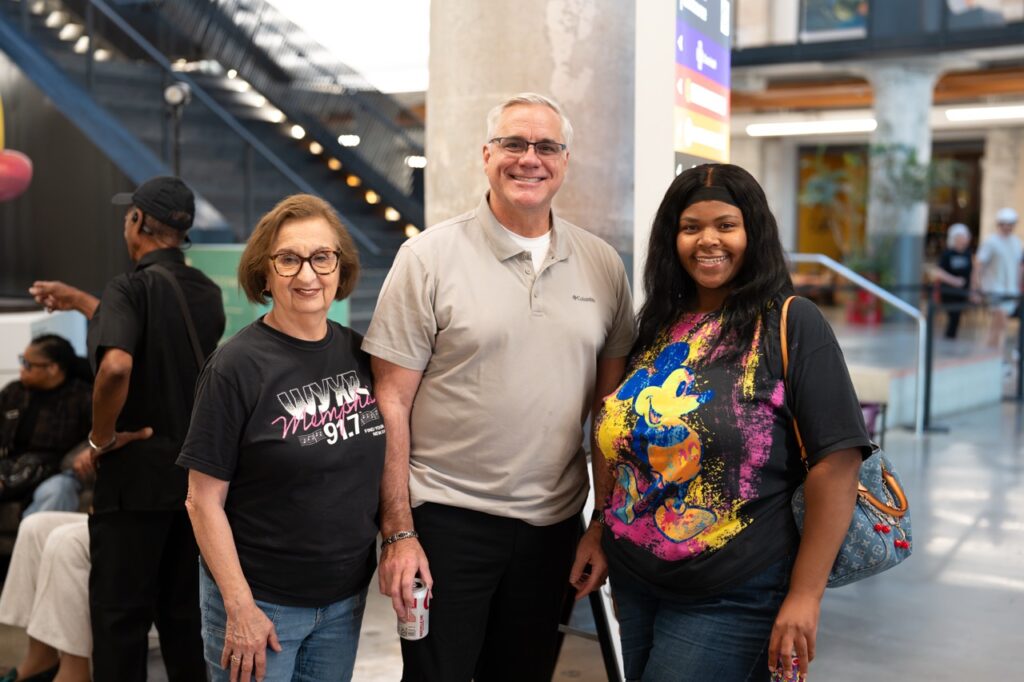Three people in WYXR T-shirts pose together for a photo.